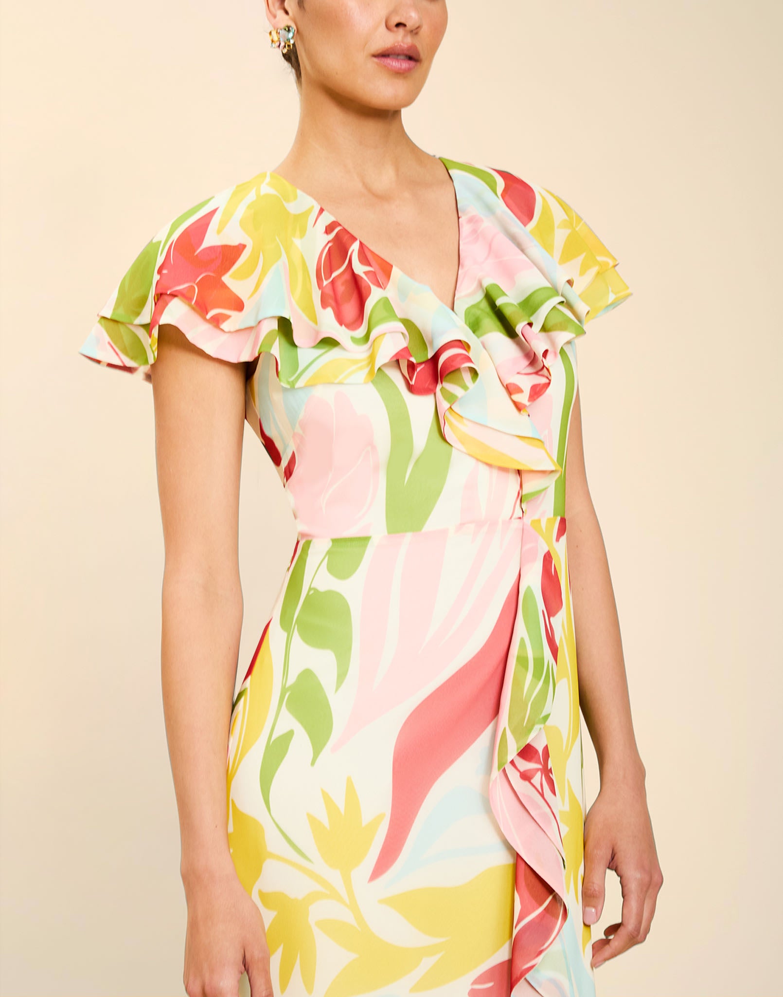 Woman wearing the Mestiza Fernanda Gown in Autumn Daydreaming print, featuring a V-neckline, cascading ruffle details, cap-style ruffle sleeves, fitted bodice, and flowing chiffon skirt.
