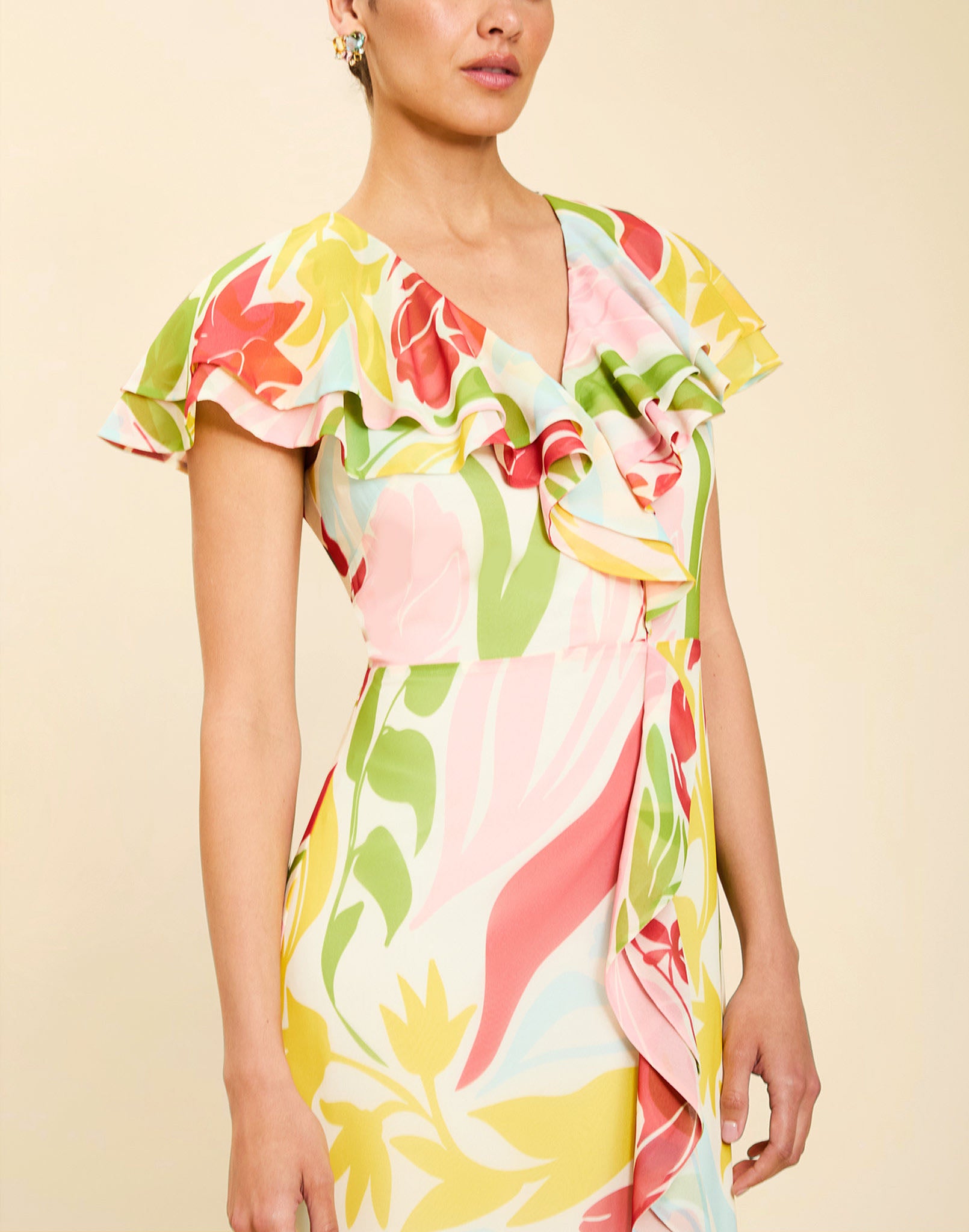 Woman wearing the Mestiza Fernanda Gown in Autumn Daydreaming print, featuring a V-neckline, cascading ruffle details, cap-style ruffle sleeves, fitted bodice, and flowing chiffon skirt.