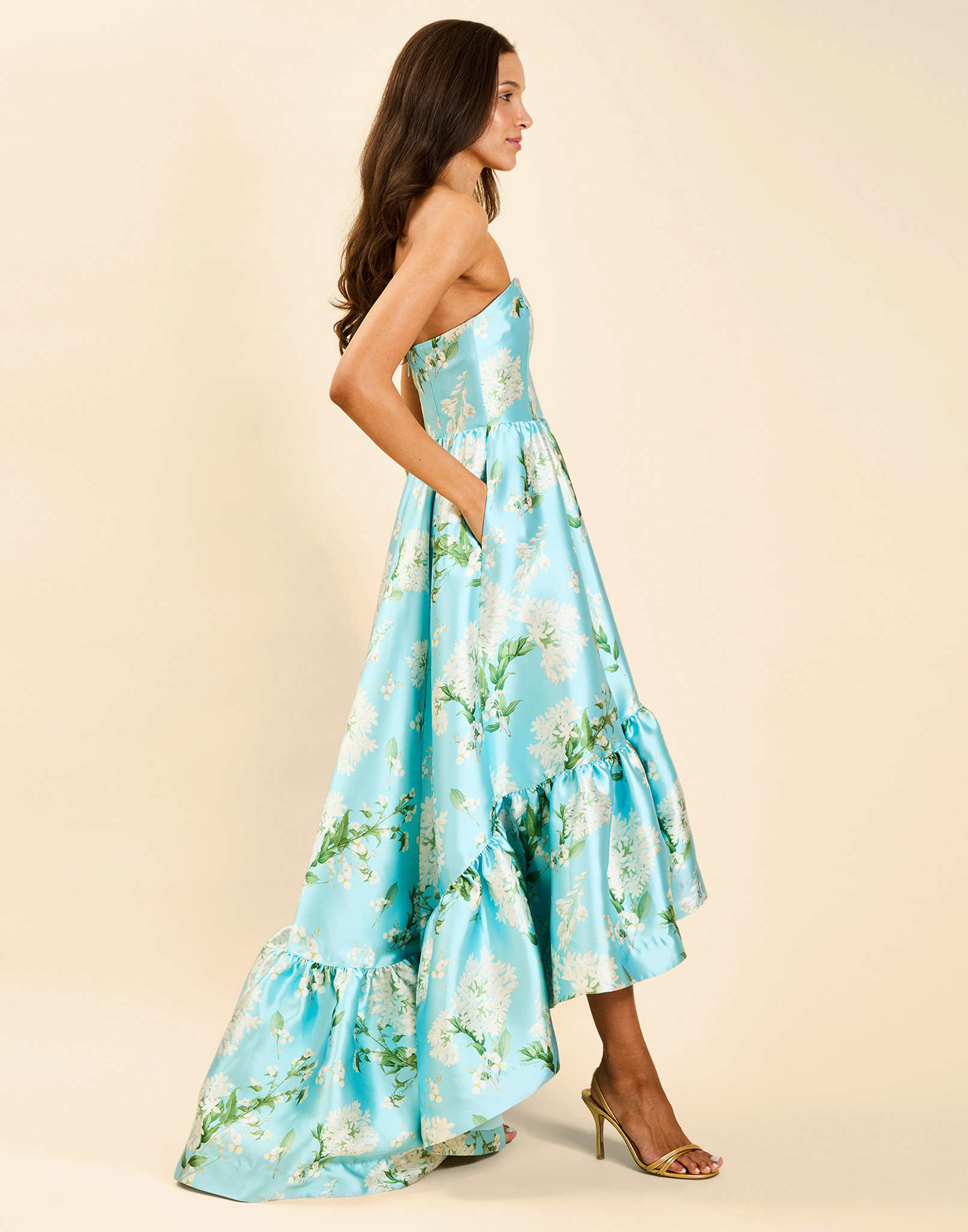 Georgiana Gown in Blue Botanica strapless poly silk twill gown with asymmetrical cascading skirt and side seam pockets.