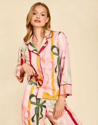 Gigi Bow Print Pajamas in Wrapped Bows with a button-front top, contrast piping, and relaxed full-length pant.