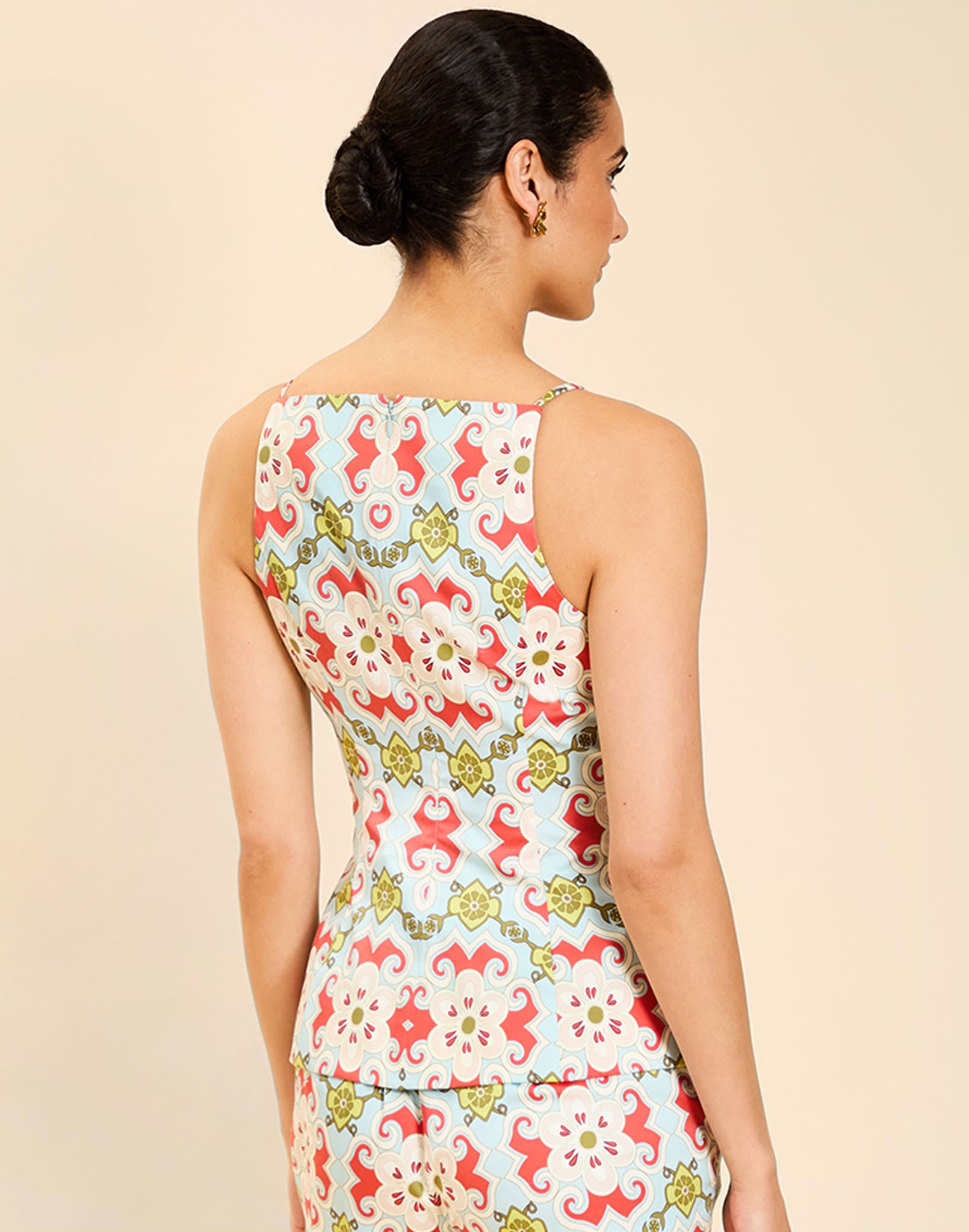 Woman wearing the Mestiza Havana Top in Quatrefoil Sierra print, featuring a bib-neck silhouette, fitted waist, princess seaming, and thin shoulder straps in crisp cotton poplin.