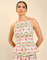Woman wearing the Mestiza Havana Top in Quatrefoil Sierra print, featuring a bib-neck silhouette, fitted waist, princess seaming, and thin shoulder straps in crisp cotton poplin.