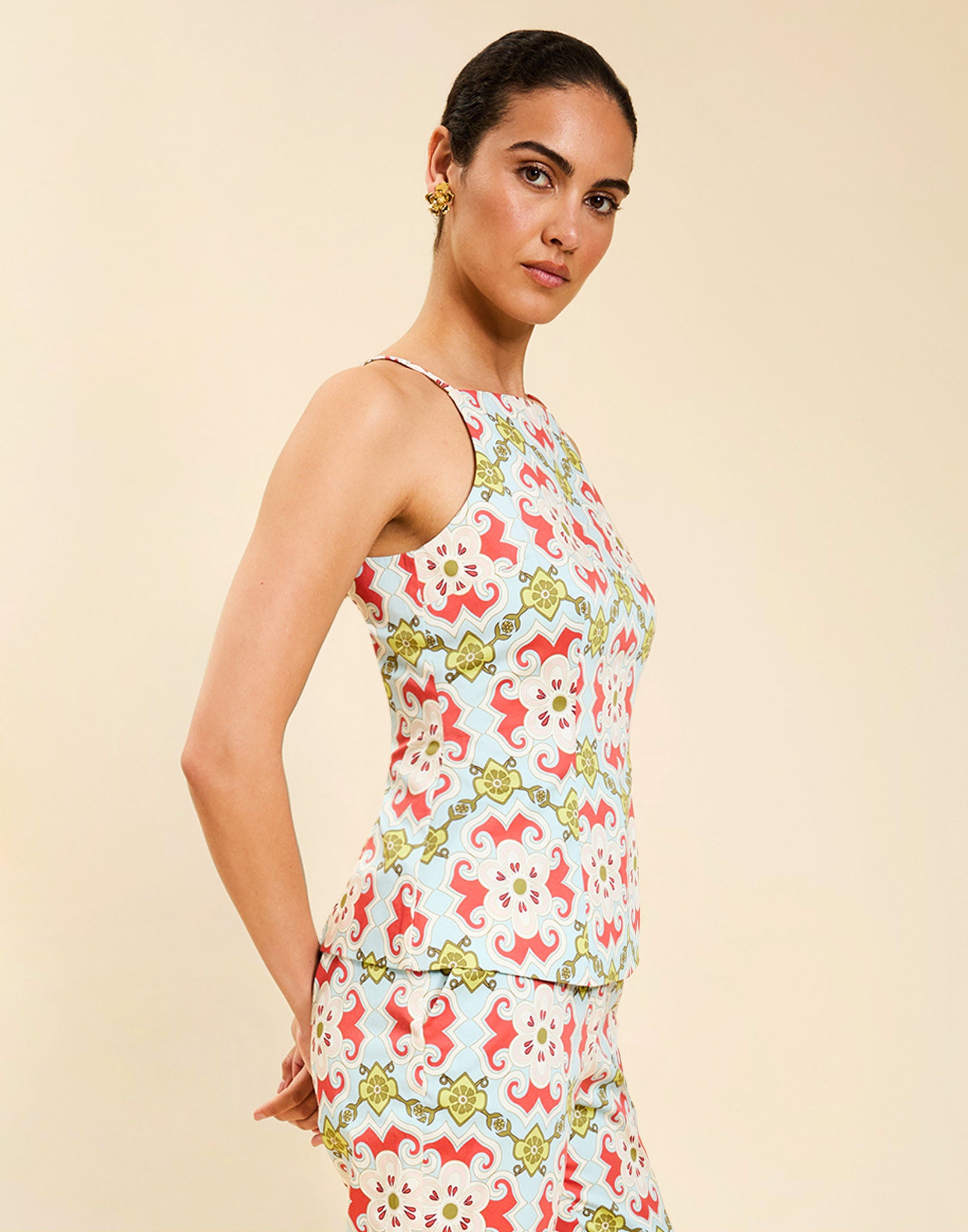 Woman wearing the Mestiza Havana Top in Quatrefoil Sierra print, featuring a bib-neck silhouette, fitted waist, princess seaming, and thin shoulder straps in crisp cotton poplin.