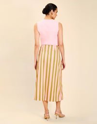 Woman wearing the Mestiza Joyah Midi Skirt in Herbes de Provence print, featuring a wrap-style silhouette, A-line shape, scalloped trim detailing, and cotton poplin fabrication.