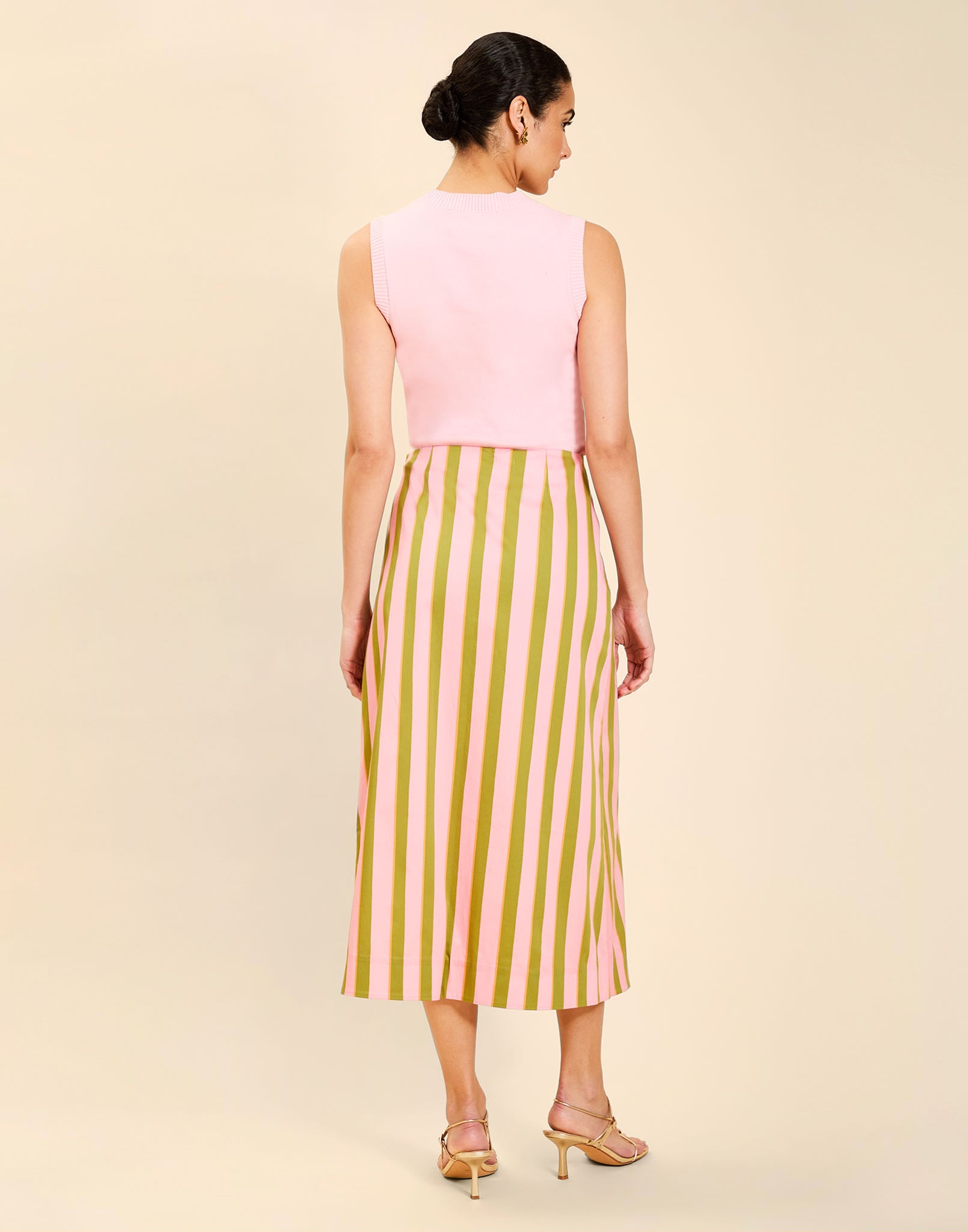 Woman wearing the Mestiza Joyah Midi Skirt in Herbes de Provence print, featuring a wrap-style silhouette, A-line shape, scalloped trim detailing, and cotton poplin fabrication.