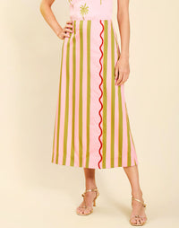 Woman wearing the Mestiza Joyah Midi Skirt in Herbes de Provence print, featuring a wrap-style silhouette, A-line shape, scalloped trim detailing, and cotton poplin fabrication.