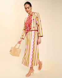 Woman wearing the Mestiza Joyah Midi Skirt in Herbes de Provence print, featuring a wrap-style silhouette, A-line shape, scalloped trim detailing, and cotton poplin fabrication.