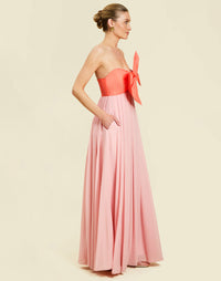 Kiss Me Knot Gown in Bloom Pink chiffon with oversized bow neckline, strapless silhouette, and flowing skirt.