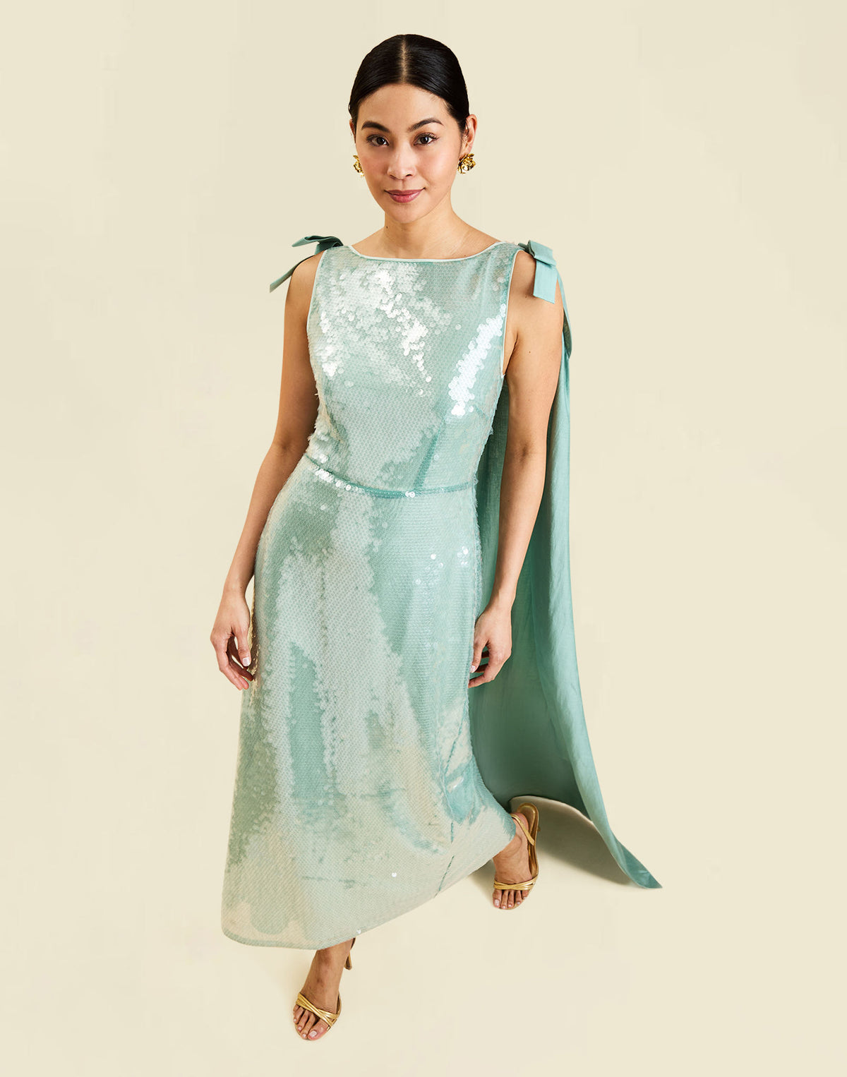 Lillian Convertible Gown in Aquarelle Blue is a sequin column gown with removable cape and bow details.