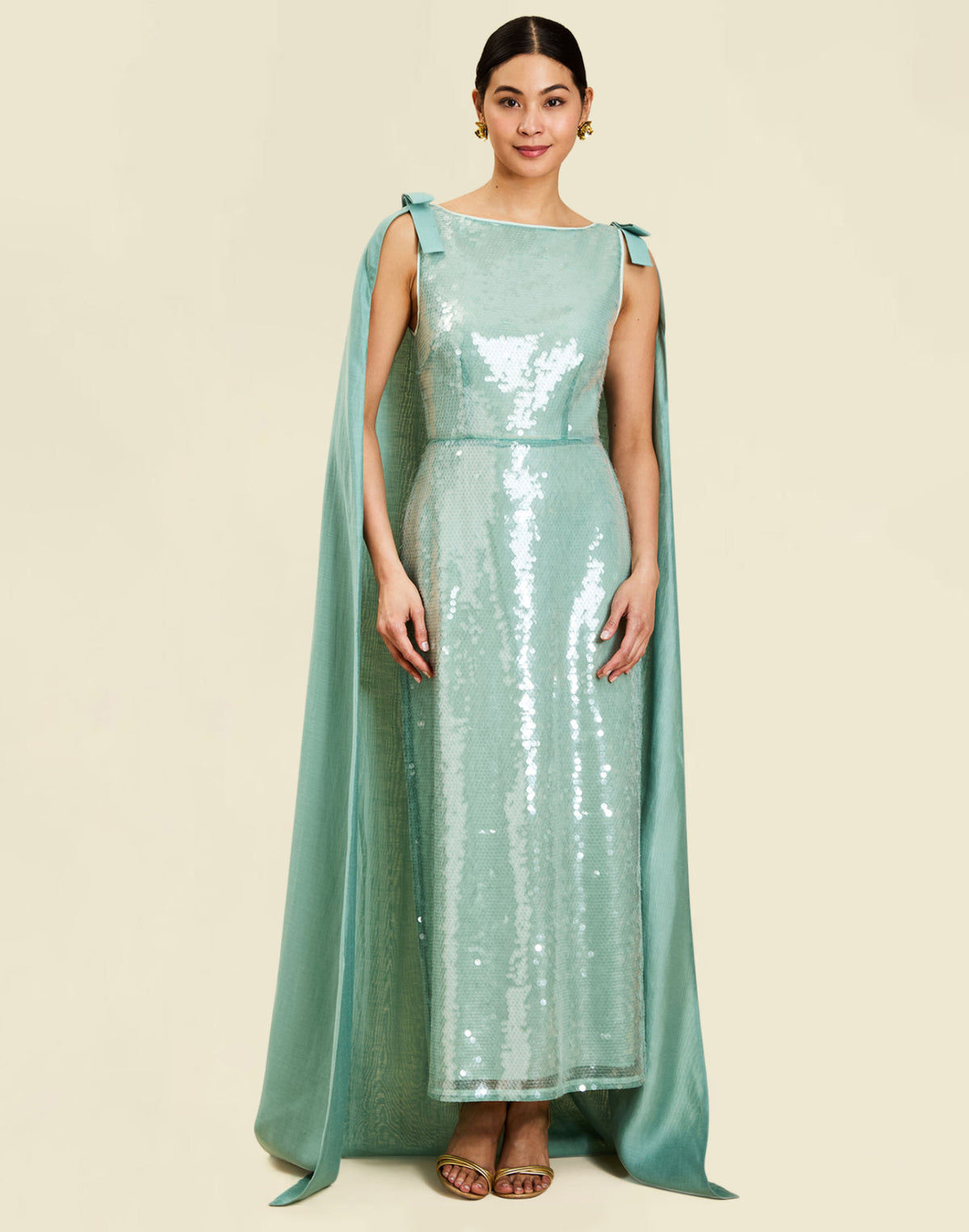 Lillian Convertible Gown in Aquarelle Blue is a sequin column gown with removable cape and bow details.