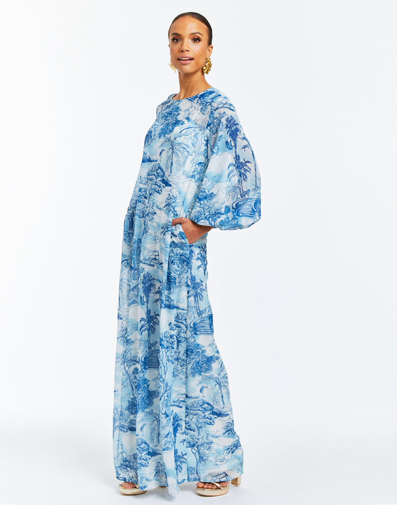 Blue and White toile printed maxi dress gown with sash tie at neck and blouson sleeves. 