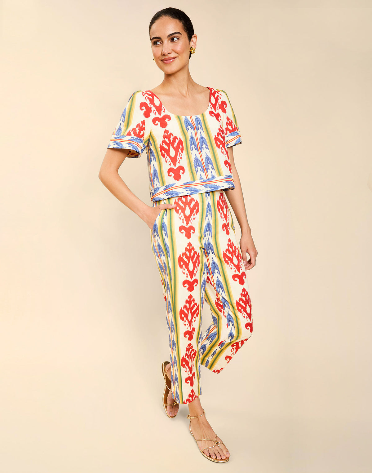 Woman wearing the Mestiza Maldives Top in Ikat Sunrise print, featuring a boxy silhouette, deep scoop neckline, pleated flutter sleeves, contrast ivory trim, and lightweight linen fabrication.