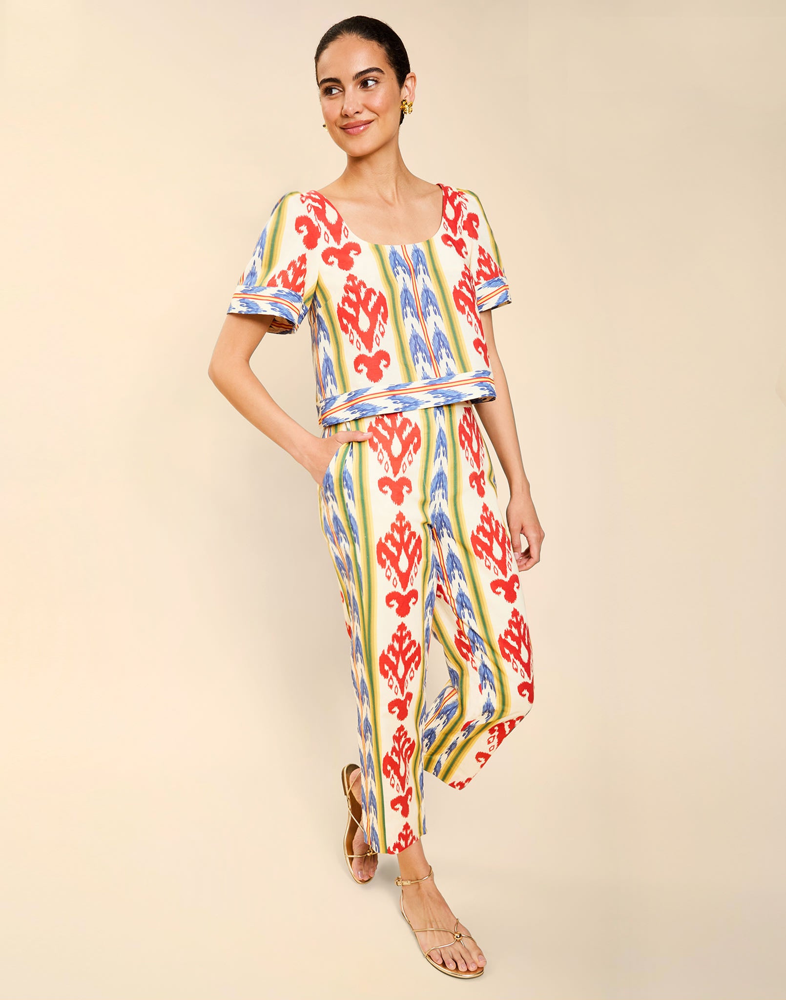 Woman wearing the Mestiza Maldives Top in Ikat Sunrise print, featuring a boxy silhouette, deep scoop neckline, pleated flutter sleeves, contrast ivory trim, and lightweight linen fabrication.