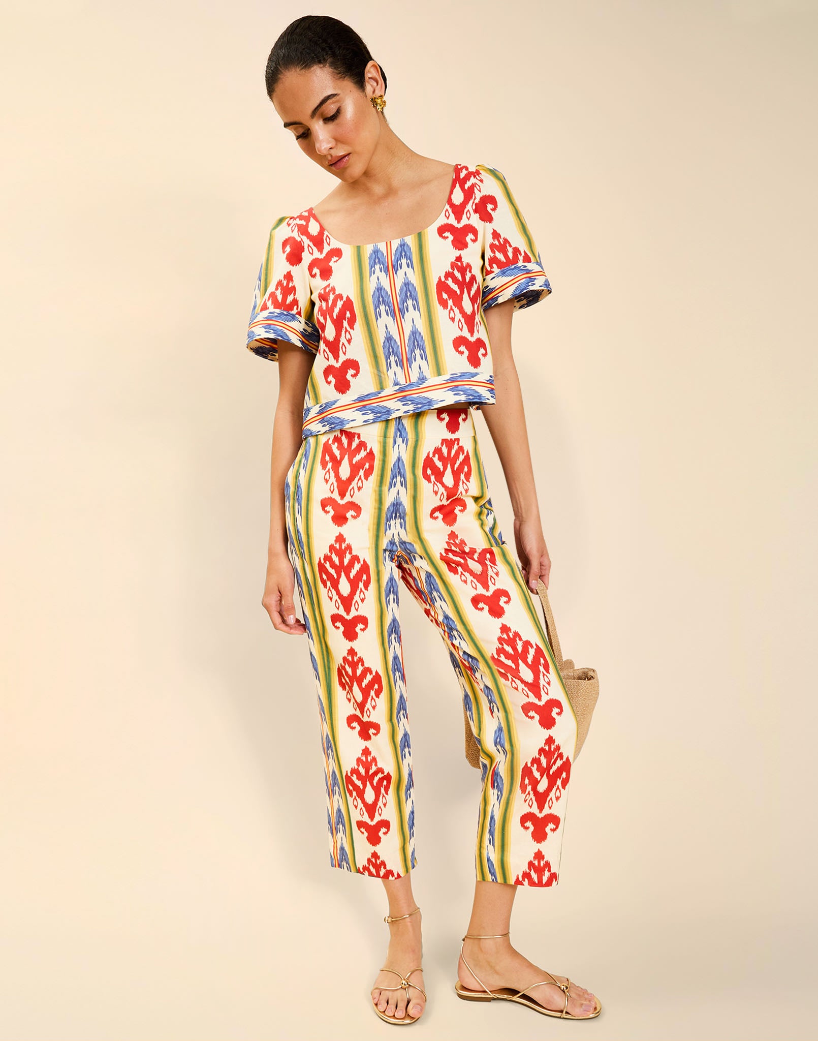 Woman wearing the Mestiza Maldives Top in Ikat Sunrise print, featuring a boxy silhouette, deep scoop neckline, pleated flutter sleeves, contrast ivory trim, and lightweight linen fabrication.