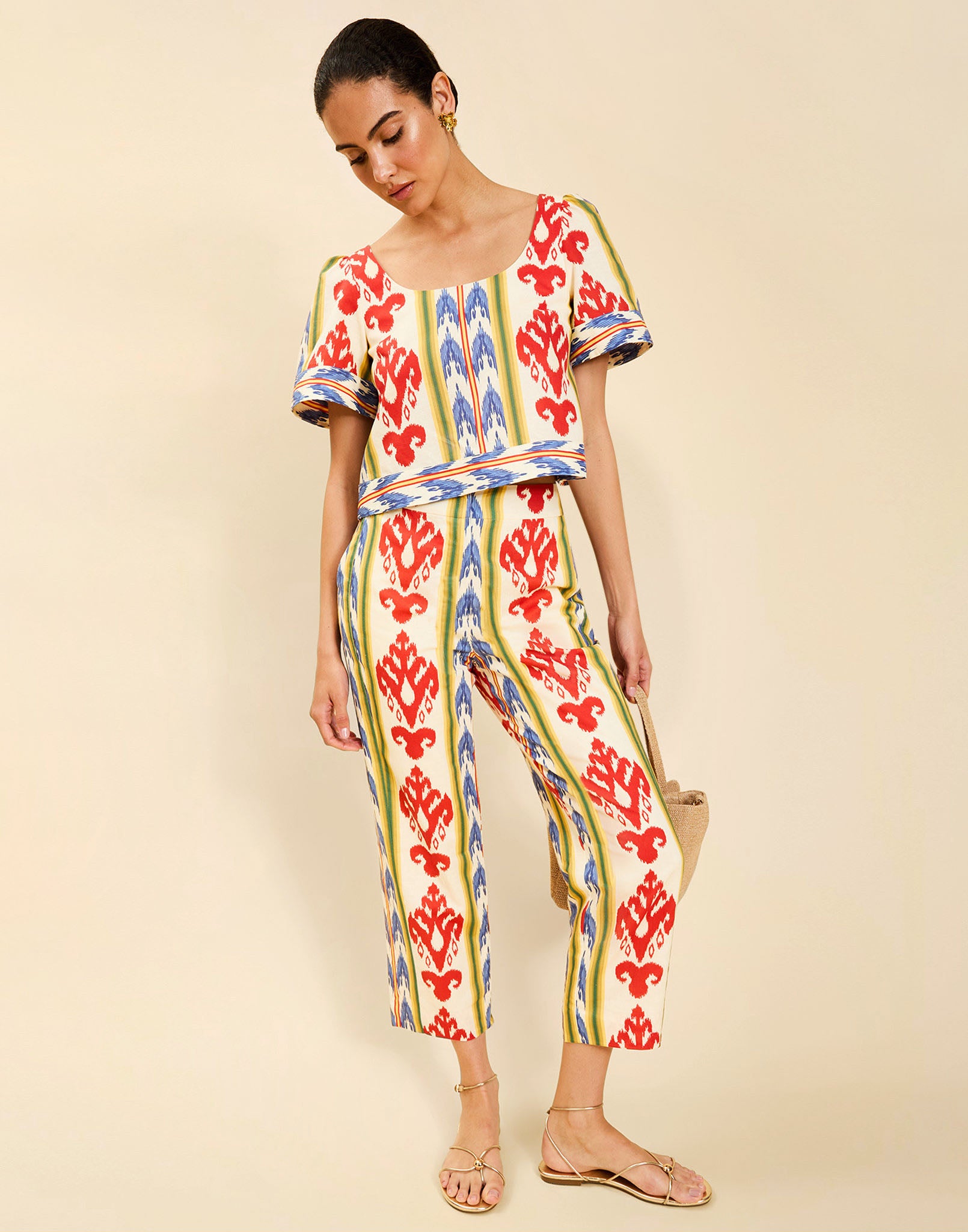 Woman wearing the Mestiza Maldives Top in Ikat Sunrise print, featuring a boxy silhouette, deep scoop neckline, pleated flutter sleeves, contrast ivory trim, and lightweight linen fabrication.