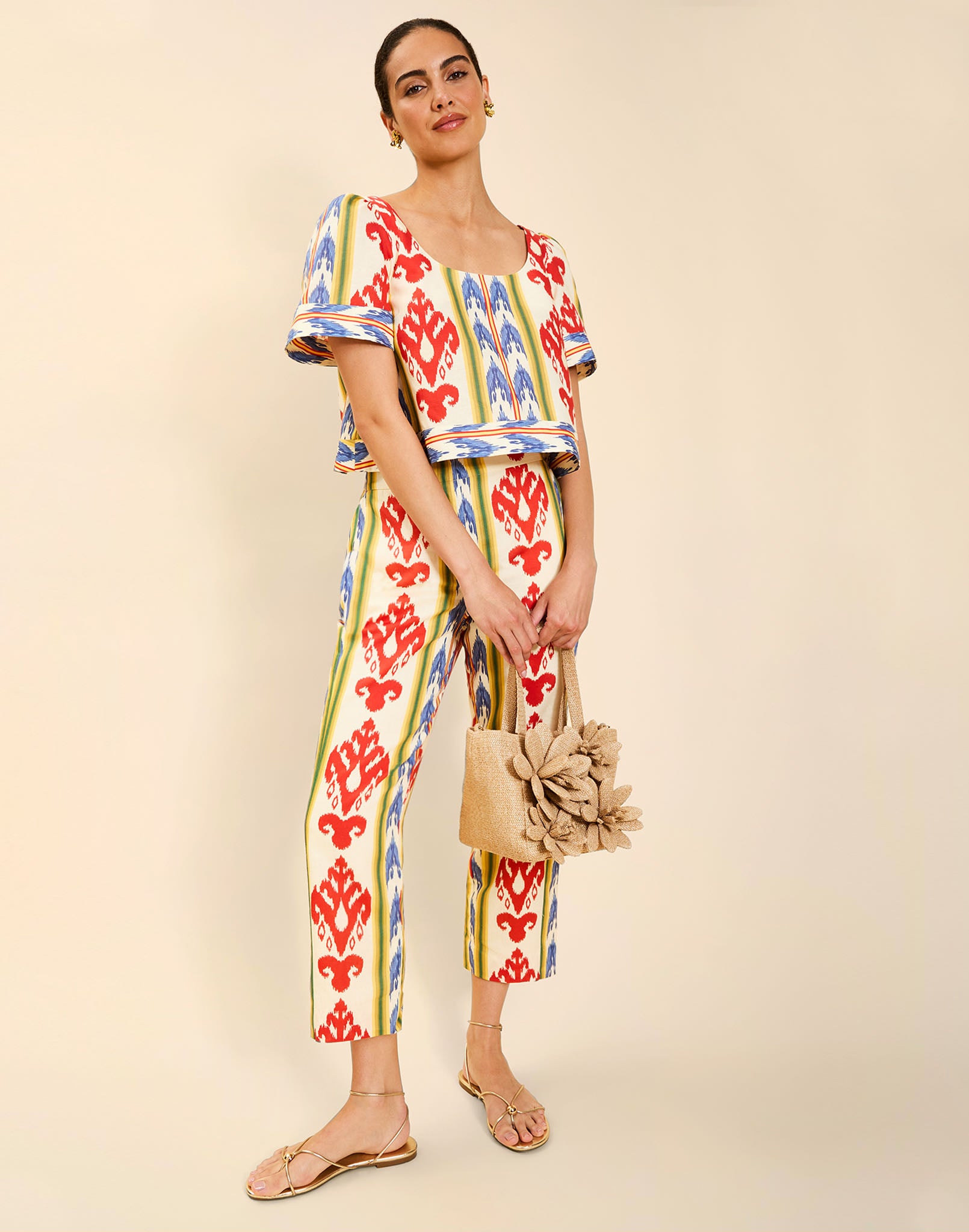 Woman wearing the Mestiza Maldives Top in Ikat Sunrise print, featuring a boxy silhouette, deep scoop neckline, pleated flutter sleeves, contrast ivory trim, and lightweight linen fabrication.