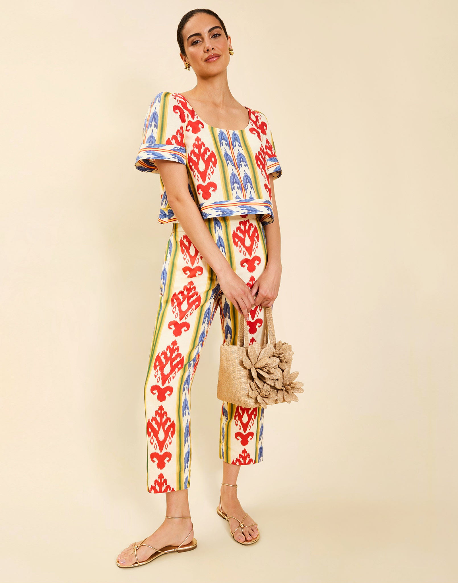 Woman wearing the Mestiza Maldives Top in Ikat Sunrise print, featuring a boxy silhouette, deep scoop neckline, pleated flutter sleeves, contrast ivory trim, and lightweight linen fabrication.
