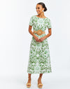 Green and ivory arabesque floral daytime midi shift dress. Fitted short sleeves, hand pockets, and bow tie detail in back with keyhole closure.