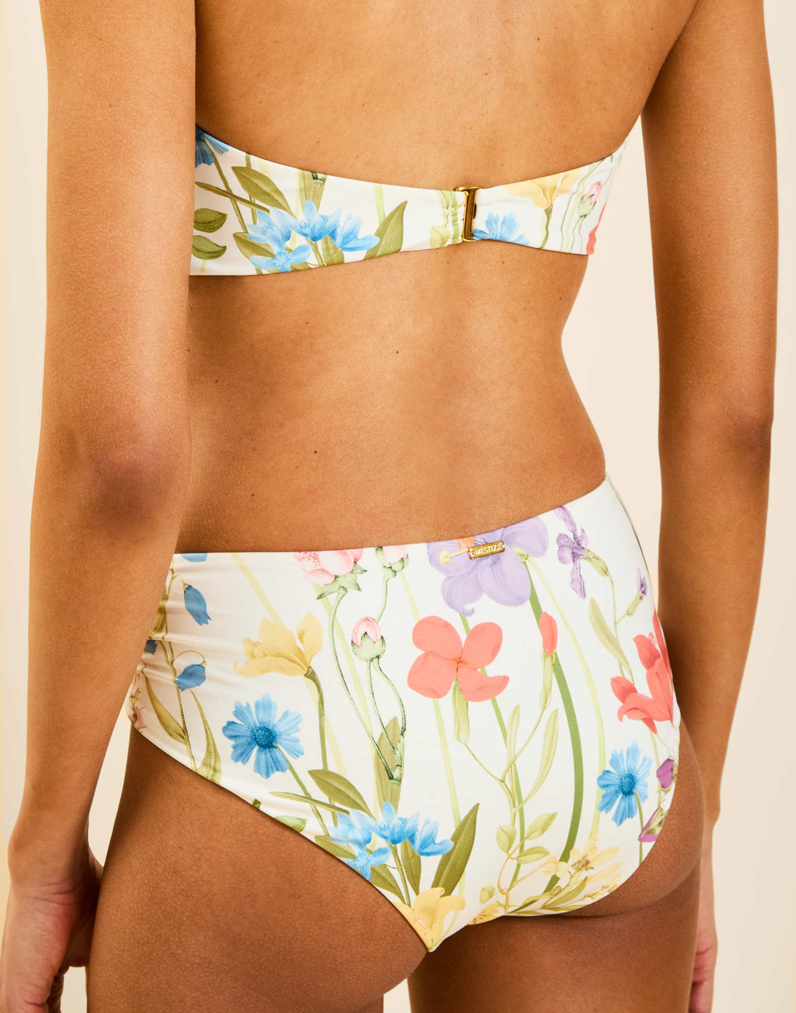 Model wearing Julien Bikini Bottom in Garden Muse with asymmetrical ruched detail and gold ring hardware at hip.