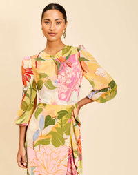 Ophelia Gown in Primrose Midnight chiffon with twisted keyhole neckline, cascading ruffle skirt, balloon sleeves, and leg slit.