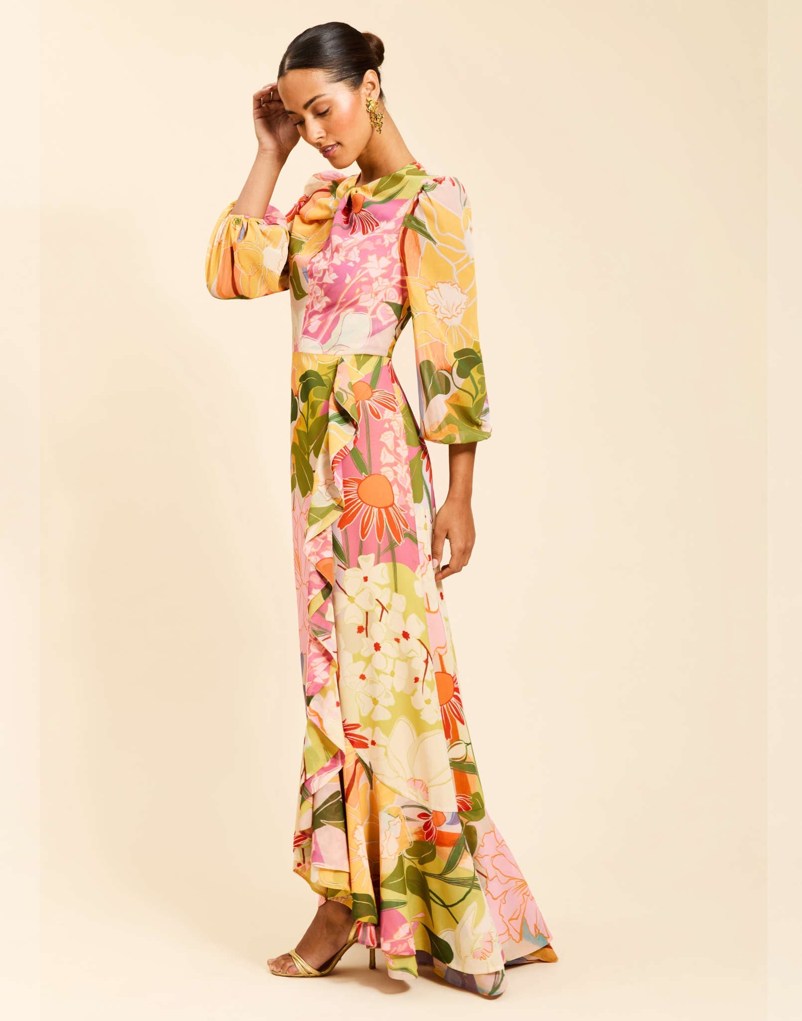 Ophelia Gown in Primrose Midnight chiffon with twisted keyhole neckline, cascading ruffle skirt, balloon sleeves, and leg slit.