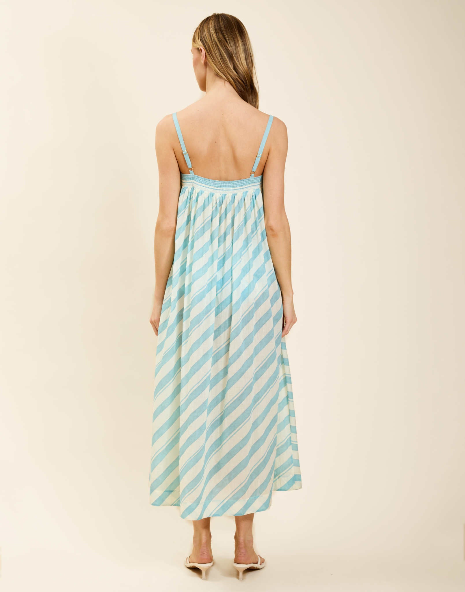 Model wearing Portofino Maxi Dress in Aegean Stripe cotton voile with straight neckline and flared silhouette.