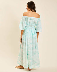 Model wearing Raffaella Midi Dress in Aegean Toile cotton voile with off-the-shoulder neckline and balloon sleeves.