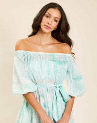 Model wearing Raffaella Midi Dress in Aegean Toile cotton voile with off-the-shoulder neckline and balloon sleeves.