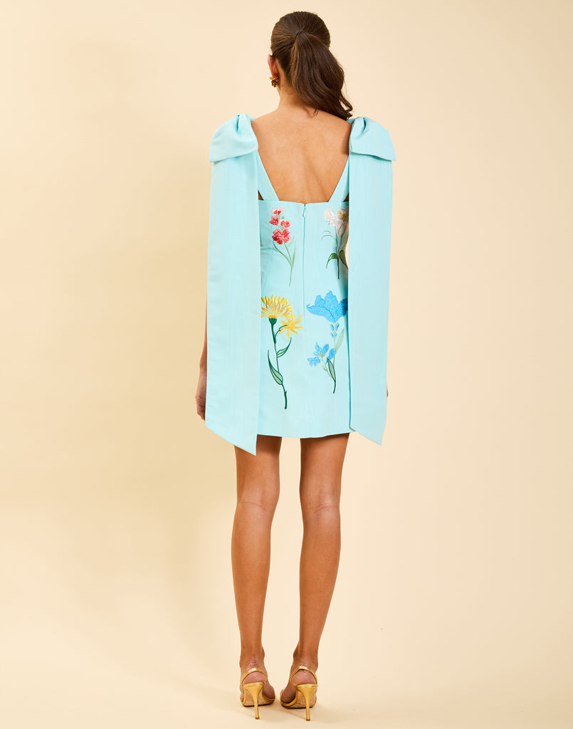 Samar Mini Dress in Blue Waltz moire with removable bow straps, floral embroidery, sweetheart neckline, and bell-shaped silhouette.