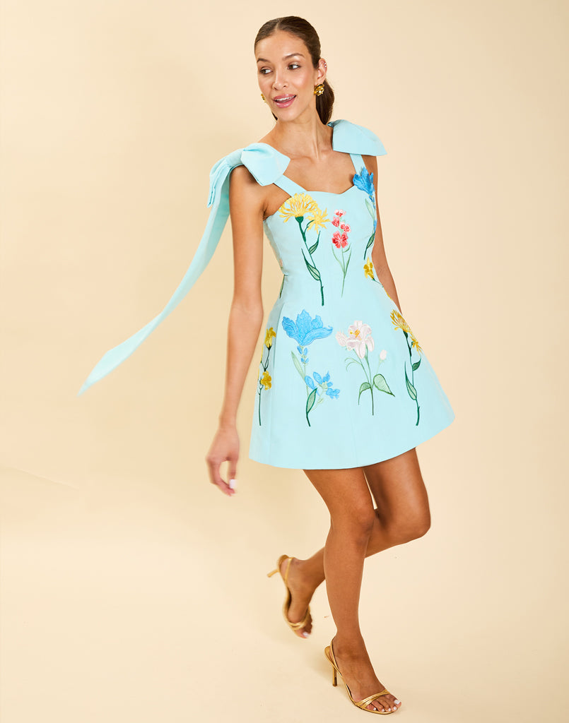 Samar Mini Dress in Blue Waltz moire with removable bow straps, floral embroidery, sweetheart neckline, and bell-shaped silhouette.