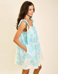 Model wearing Solenn Mini Dress in Aegean Flourish cotton voile with straight neckline and relaxed silhouette.