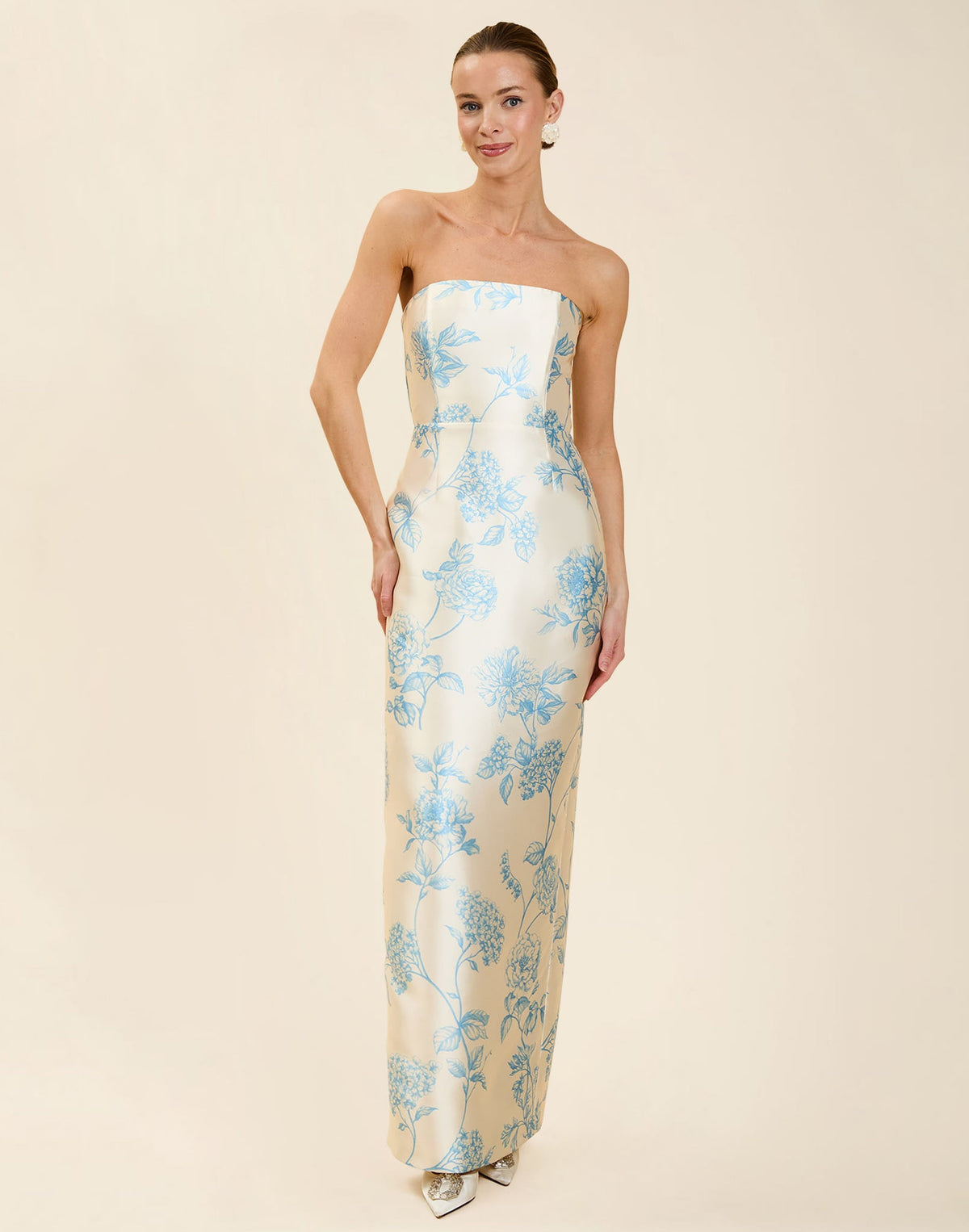 Solstice Gown in Powder Batiste poly silk twill with strapless neckline, removable pleated band, statement bow detail, and fitted gown silhouette.
