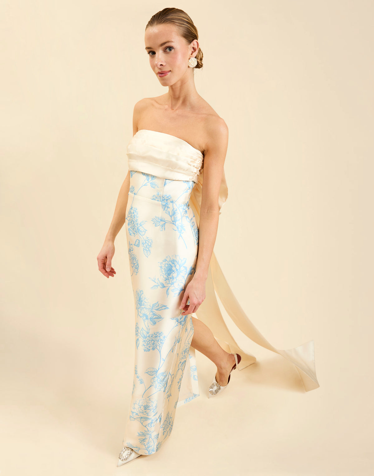 Solstice Gown in Powder Batiste poly silk twill with strapless neckline, removable pleated band, statement bow detail, and fitted gown silhouette.
