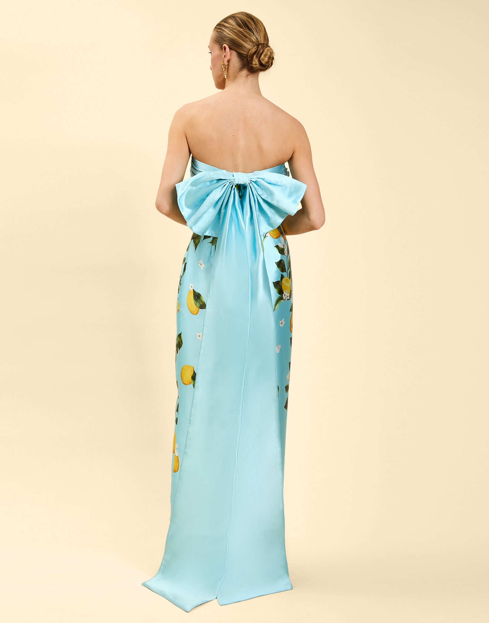 Solstice Gown in Sorrento Citrus poly silk twill with strapless neckline, removable bow, convertible bodice, and side pockets.