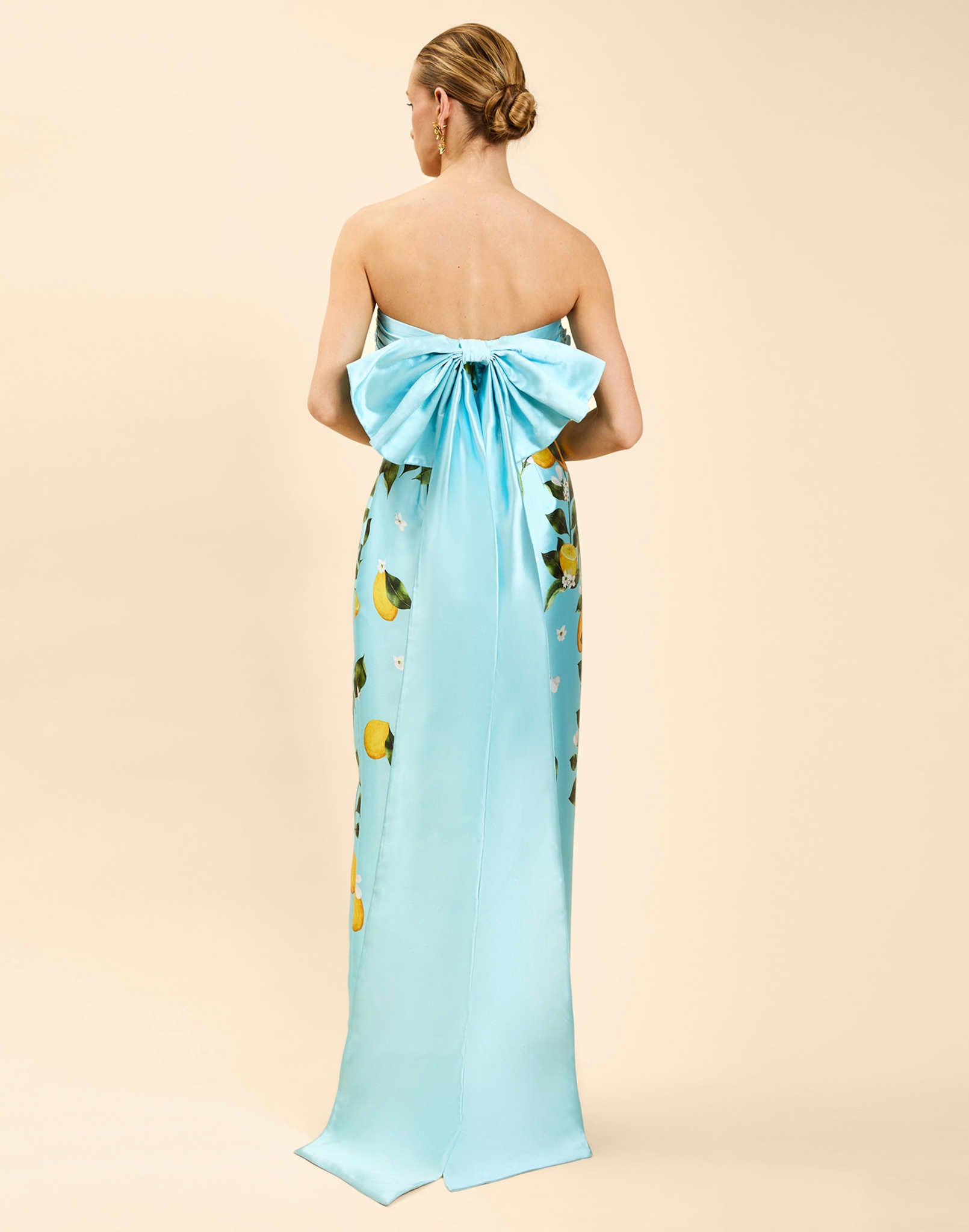 Solstice Gown in Sorrento Citrus poly silk twill with strapless neckline, removable bow, convertible bodice, and side pockets.