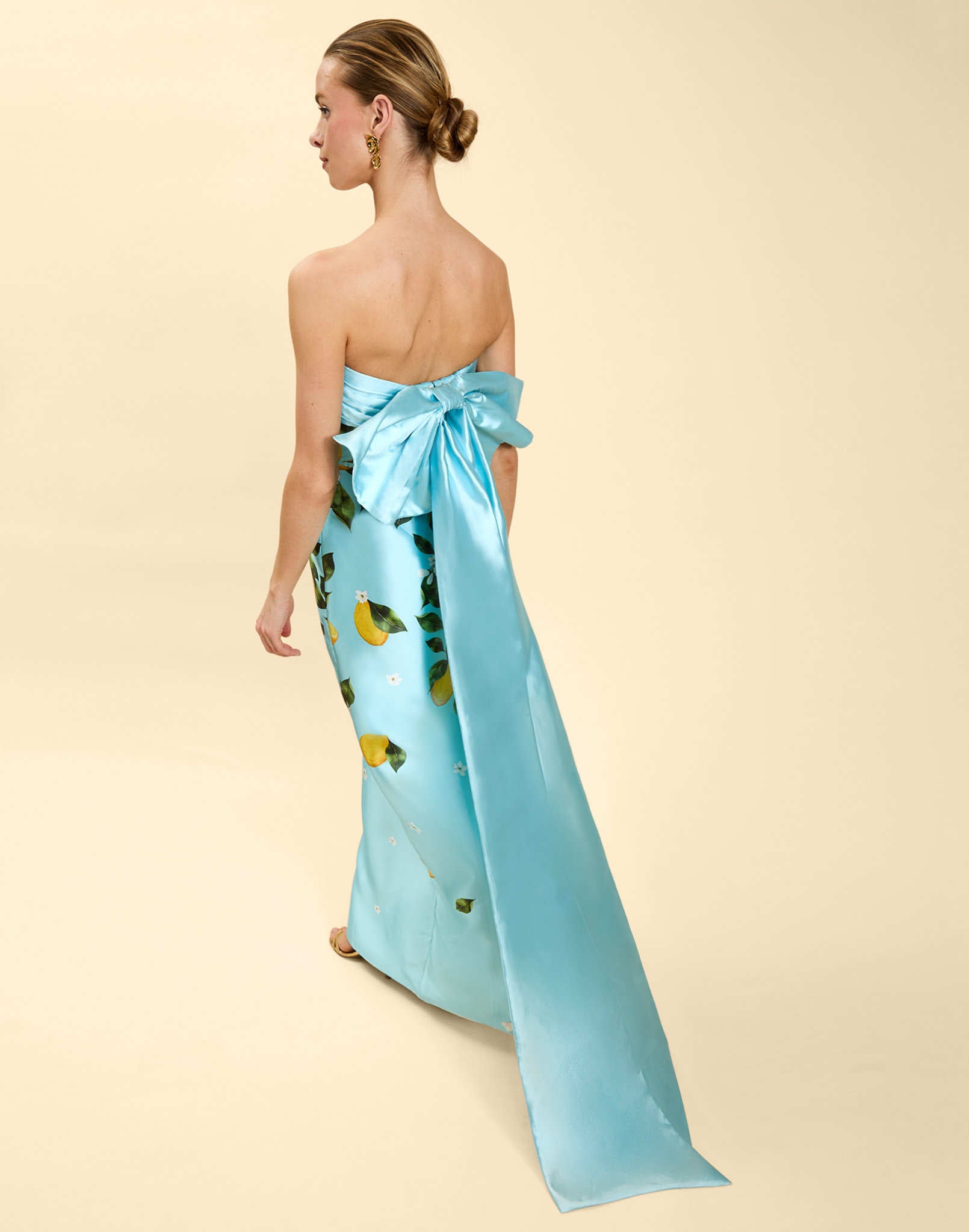 Solstice Gown in Sorrento Citrus poly silk twill with strapless neckline, removable bow, convertible bodice, and side pockets.