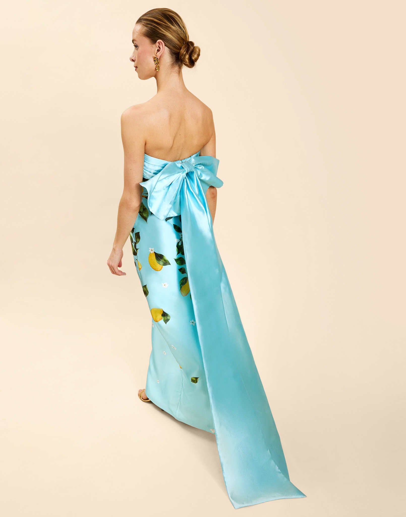 Solstice Gown in Sorrento Citrus poly silk twill with strapless neckline, removable bow, convertible bodice, and side pockets.