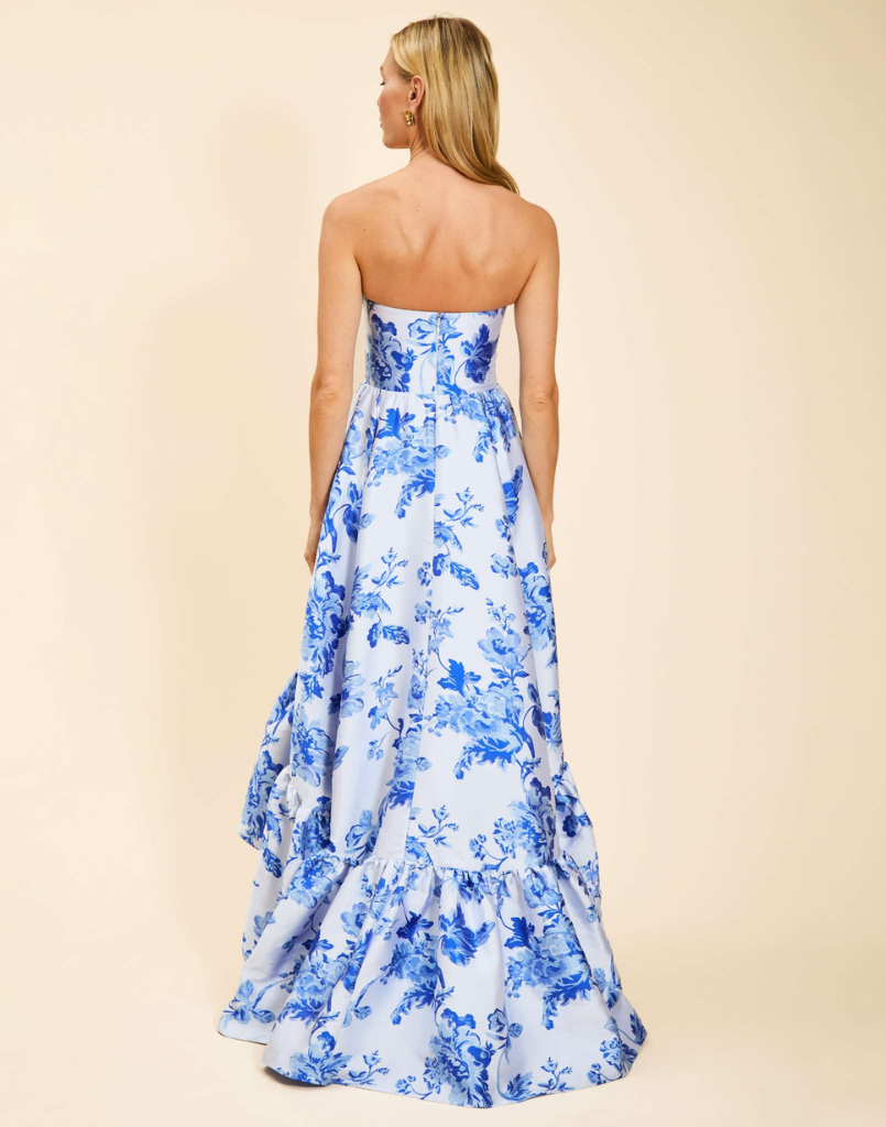 Strapless gown in Porcelain Blue Jacquard featuring a fitted bodice, cascading asymmetrical skirt, removable straps, and functional pockets.