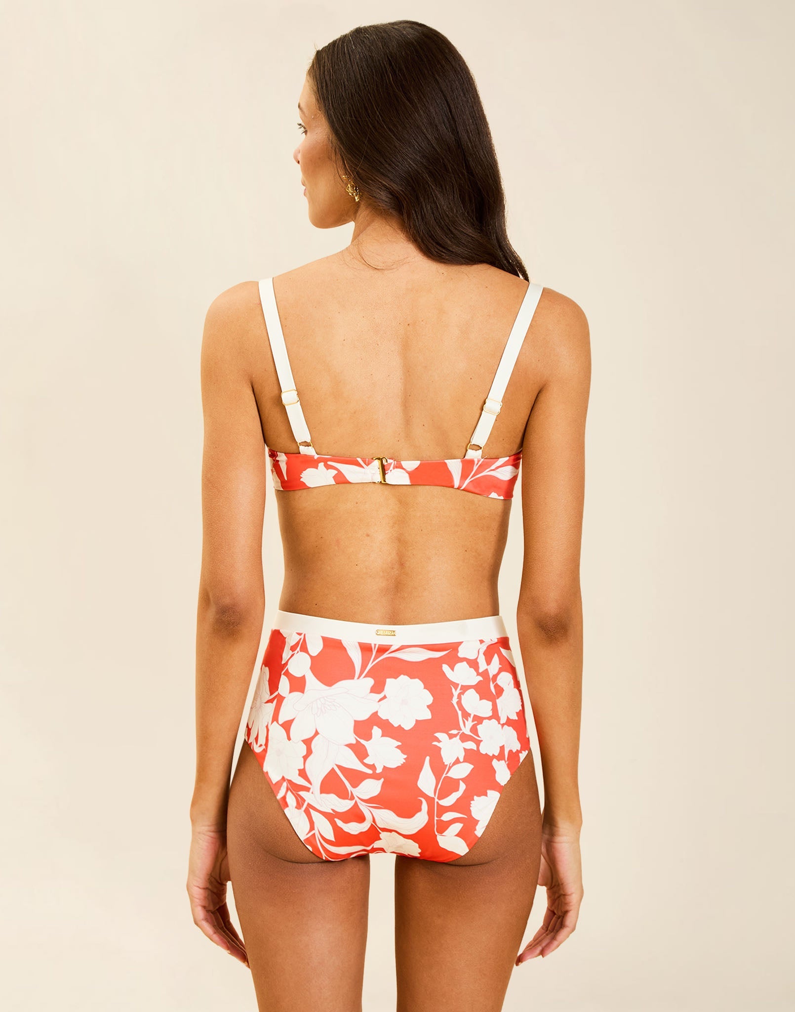 Model wearing Matera High-Waist Bikini Bottom in Huckleberry Mandarin with bow detail and full back coverage.