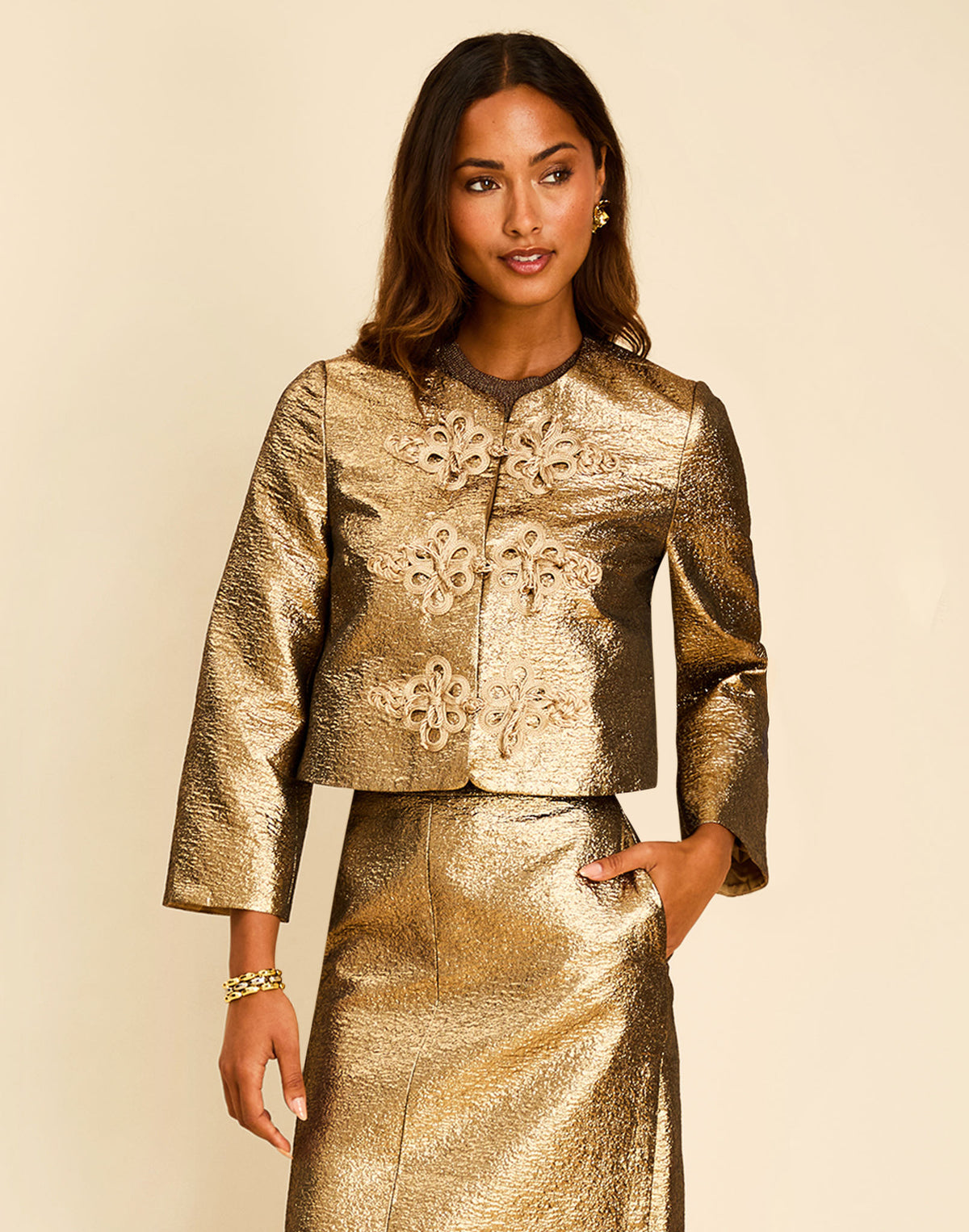 Vienna Crop Jacket in Gold with a crew neckline, bracelet-length sleeves, and gold frog clasp closure.

